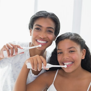 A Mom And Daughter Brushing Their Teeth